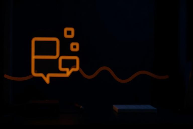 Balões de conversa luminosos sobre fundo escuro